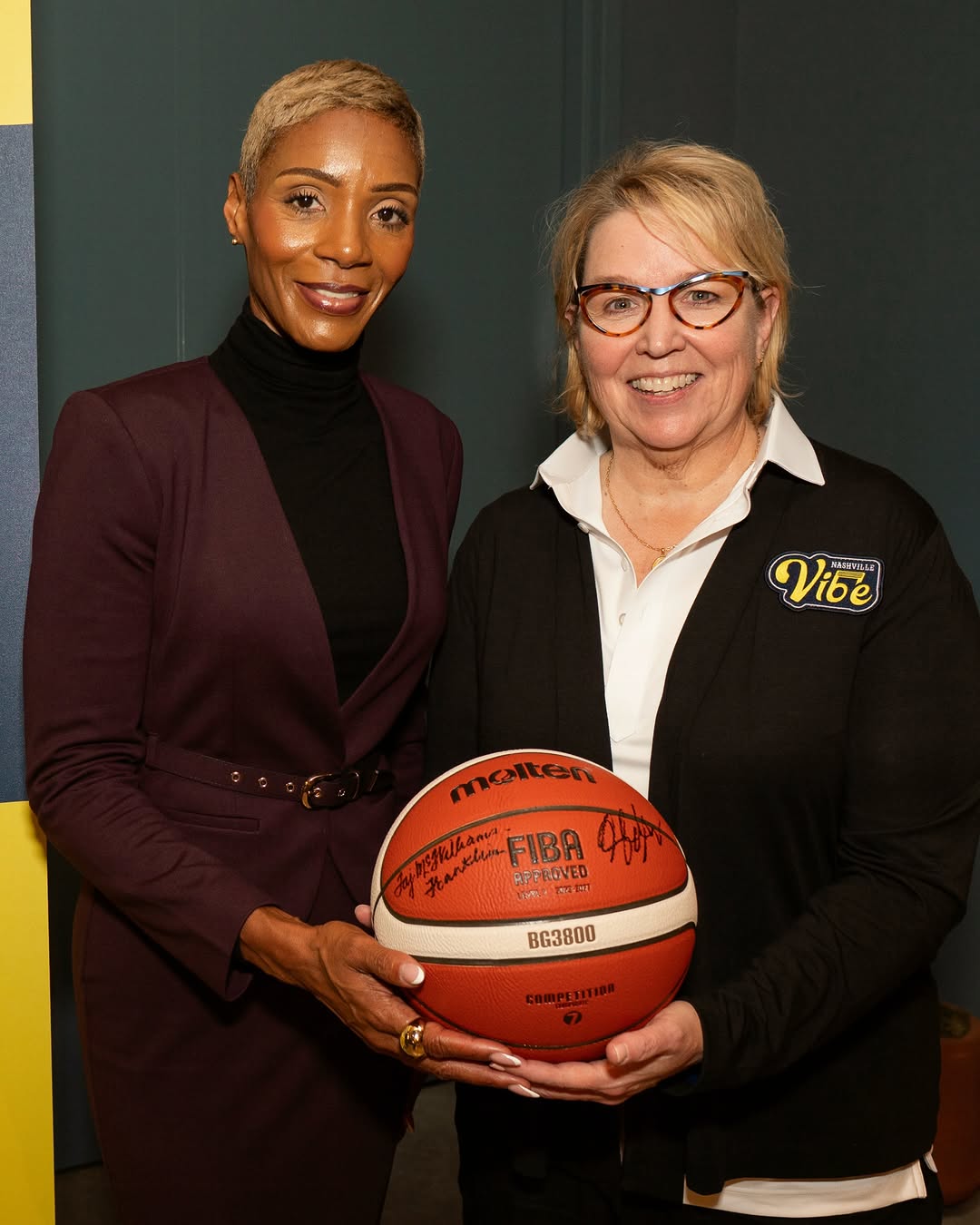 Nashville Vibe head coach Yolanda Moore at her welcome event, holding a signed basketball